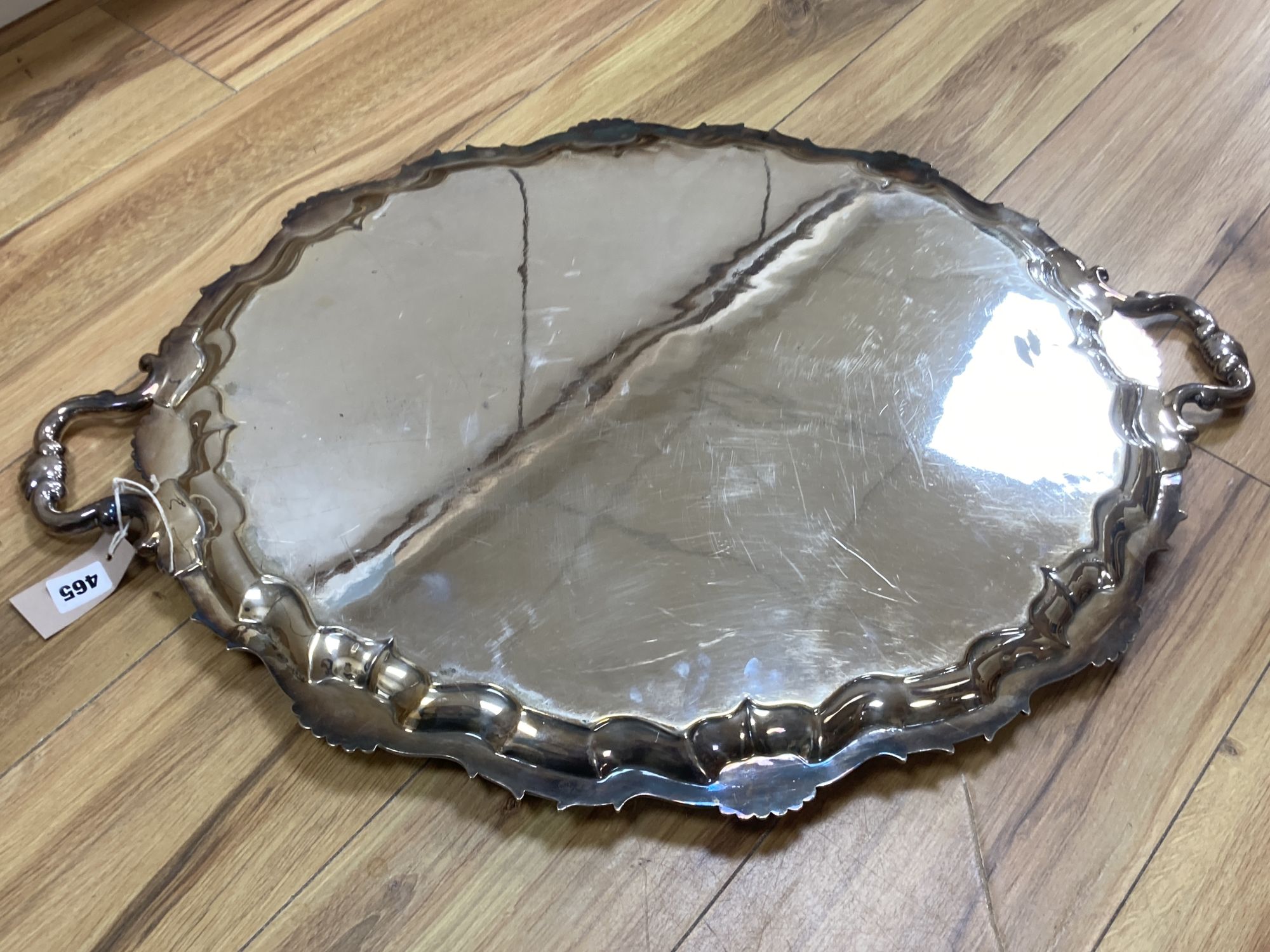 A large plated twin-handled shaped oval tray with shell and scroll border, L 76cm overall